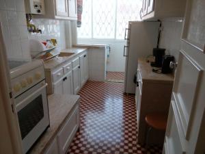 里斯本Voyage 63的厨房配有白色橱柜和红色及白色的瓷砖地板。