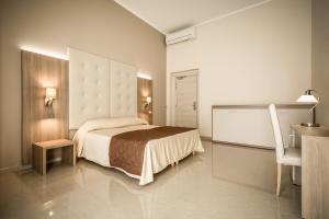 热那亚贝尔索吉奥诺酒店的一间卧室配有一张床、一张桌子和一把椅子