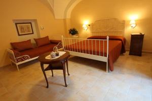 卡萨拉诺B&B Ippocastano的一间卧室配有一张床、一张沙发和一张桌子