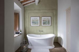 卡斯德尔诺沃贝拉登卡Borgo Argiano的浴室设有白色浴缸,拥有绿色的墙壁