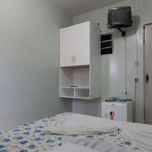 卡鲁阿鲁Pousada Ipojuca的一间卧室配有一张床,墙上配有电视