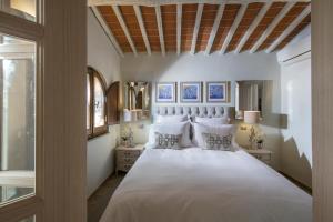 卡斯德尔诺沃贝拉登卡Borgo Argiano的卧室配有一张带白色床单和枕头的大床。