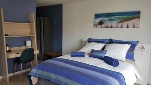 Sainte-Eulalie-en-BornLa Grange du Born的一间卧室配有一张蓝色墙壁的床和一张书桌
