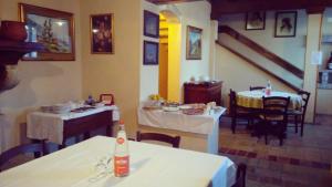 CeresaraCorte Pioppazza的一间用餐室,配有两把桌子和椅子以及一张带瓶子的桌子