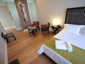 布宜诺斯艾利斯巴迪欧斯圣铁莫酒店的酒店客房带一张大床和椅子