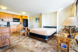 檀香山Sweetwater at Waikiki, VRI Americas的酒店客房带一张床和一个厨房