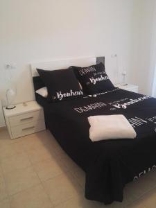 佩尼斯科拉Apartamento Ariel的一张黑色的床,上面有黑白枕头
