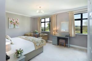 奇彭纳姆Stanton Manor Hotel的一间卧室配有一张床、一张书桌和窗户。