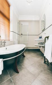 奇彭纳姆Stanton Manor Hotel的带浴缸和盥洗盆的大浴室