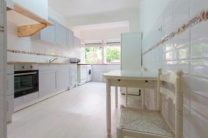 里斯本Rato Deluxe by Homing的厨房配有白色橱柜和桌子