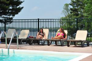 威斯康星戴尔贝克斯日落海湾度假酒店的两个女人坐在游泳池旁的椅子上