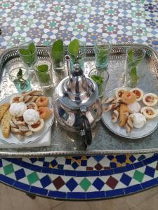 拉巴特dar wassim el ghali的一张桌子,上面放着两盘食物和茶壶