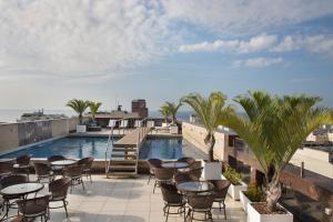 里约热内卢皇家里约宫殿酒店的一个带桌椅的屋顶露台和一个游泳池