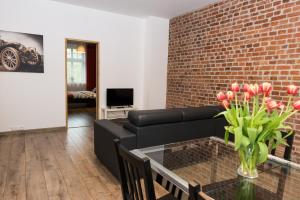 卡托维兹Apartment Zamulkowa Katowice的客厅配有黑色沙发和砖墙
