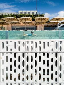 里约热内卢埃米利亚诺里奥酒店的在带遮阳伞的游泳池游泳的人