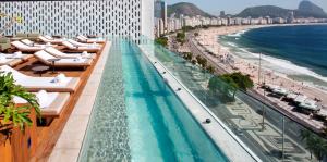 里约热内卢埃米利亚诺里奥酒店的酒店游泳池设有躺椅和海滩