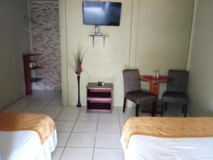 TigreHotel Boutique Malibu Los Sueños的酒店客房设有两张床和一台墙上的电视。