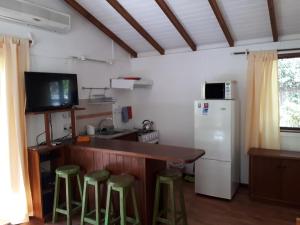 Ocean ParkCabañas Del Potrero的厨房配有带凳子的柜台和冰箱。