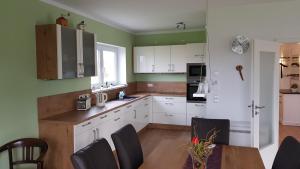莱比锡Ferien-Haus-Leipzig的厨房配有白色橱柜和桌椅