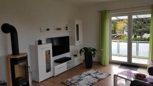 莱比锡Ferien-Haus-Leipzig的客厅配有平面电视和窗户。