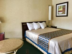 莱文沃思River's Edge Lodge的酒店客房配有一张床铺和一张桌子。