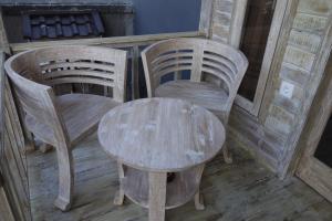 蓝梦岛瓦勒特乐园经济型酒店的一张木桌、两把椅子、一张桌子和一张桌子