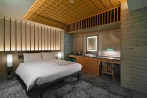 东京HOTEL HILLARYS Akasaka的一间带一张床和一张书桌的卧室和一间厨房