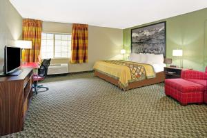 麦岭速8丹佛西酒店的酒店客房配有一张床、一张书桌和一台电视。