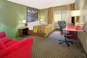 麦岭速8丹佛西酒店的酒店客房配有一张床、一张桌子和一把椅子。