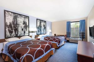 IndianolaSuper 8 by Wyndham Indianola的酒店客房设有两张床和一台平面电视。