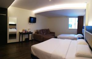 诗巫苏拉酒店的酒店客房,配有床和沙发