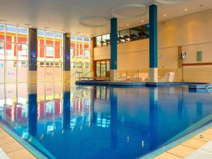 戈特Lady Gregory Hotel, Leisure Club & Beauty Rooms的大楼内的一个蓝色海水游泳池