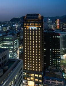 首尔南大门伊娜套房酒店的城市的一座有灯光的建筑