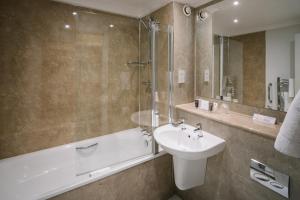 鲍内斯温德米尔林德霍伊酒店的浴室配有水槽、淋浴和浴缸。