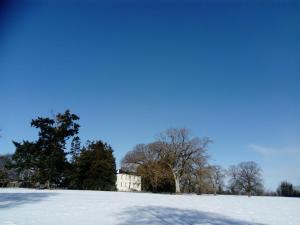 朗福德Augherea House的雪覆盖的田野,有房子的背景