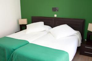 阿维拉圣塞贡多格兰旅馆的一间卧室设有两张带绿色墙壁的床