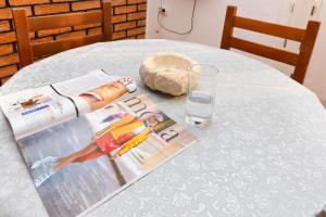蒂瓦特Apartments Ivo Bozinovic的一张桌子,上面有杂志和一杯水