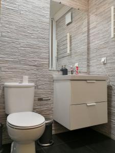 普拉亚达维多利亚Central Praia Beach House的浴室配有白色卫生间和盥洗盆。