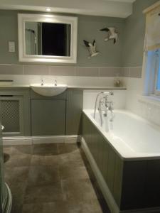 金斯林斯图尔特之家酒店的浴室配有盥洗盆和浴缸。