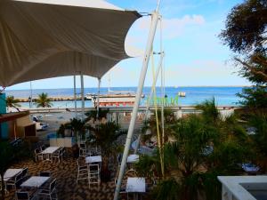 克拉伦代克Hotel Islander Bonaire的配有遮阳伞的餐厅享有海滩美景