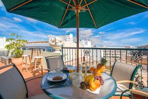 阿雷西费Rooms & Suites Terrace 4C的阳台的桌子和遮阳伞