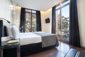 巴塞罗那埃克兰布拉斯博科瑞雅酒店的酒店客房设有一张床和一个大窗户