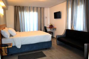 杰迪代Hotel Centre Ville的酒店客房,配有床和沙发