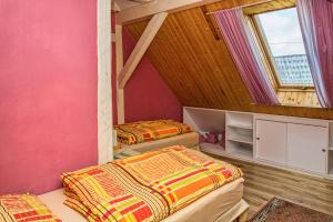 凯日马罗克Penzión u Maroša的配有粉红色墙壁和窗户的客房内的两张床