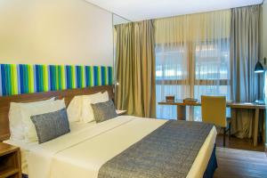 里约热内卢普罗迪吉桑托斯杜蒙酒店的酒店客房设有一张大床和一张书桌。