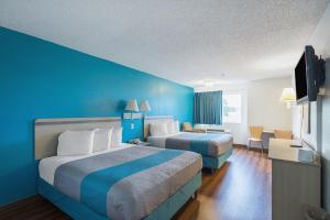 劳伦斯Motel 6-Lawrence, KS的酒店客房设有两张床和蓝色的墙壁。