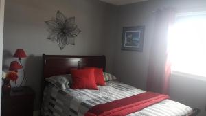 博纳维斯塔Aggie's B&B的一间卧室配有一张带红色枕头的床