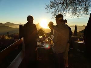 克鲁兹·德·特赫达Mountain Hostel Finca La Isa的一群人,在日落时分站在桌子旁