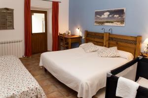 LizasoCasa Rural Flor de Vida - B&B的一间卧室设有两张床、一张桌子和一个窗口