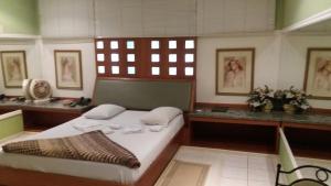波苏斯-迪卡尔达斯Heru's Motel的一间卧室配有一张床、一张书桌和一个窗户。